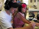 A well-dressed radio princess wears a flower in her hair and a matching pair of headphones, while tuning for 6m signals
